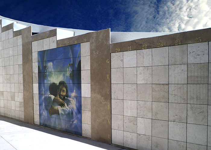 Criptas Pared exterior de mármol con imagen religiosa de abrazo y numeración en el borde