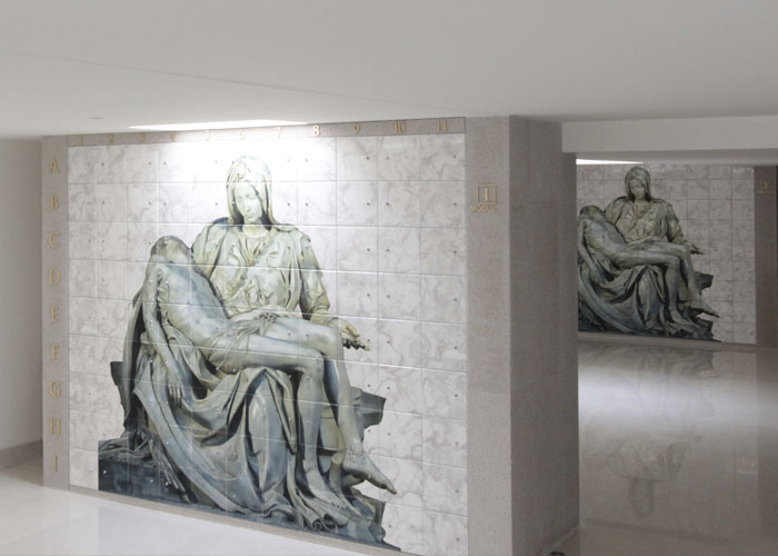 Criptas Detalle de una pared interior con imagen de una escultura religiosa de la Piedad en mármol