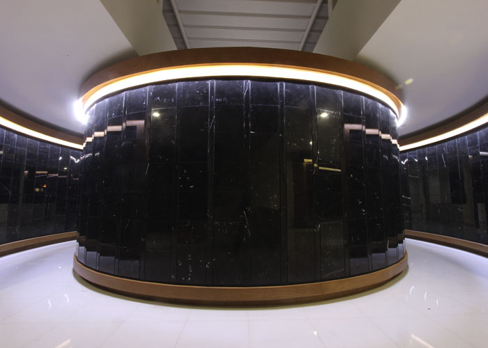 Criptas Área interior con pared curva de mármol negro y detalles de iluminación superior