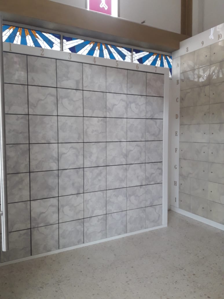 Criptas Muro de mosaico gris con numeración, debajo de una ventana con vitral en tonos azules y dorados