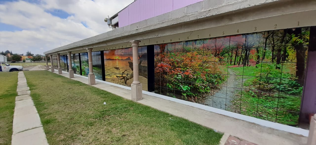 Criptas Exterior con una serie de murales paisajísticos en mosaico, numerados en la parte superior, con columnas decorativas entre cada sección